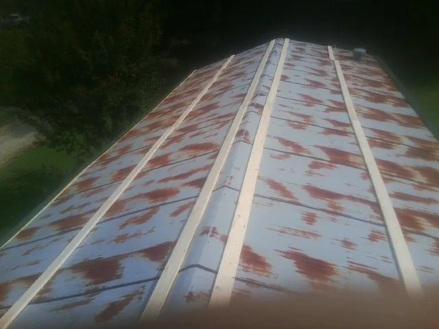 Rusted metal roof panels with new wood purlins before replacement — Storm Damage Roof Repair in Byron by Roofing Brothers
