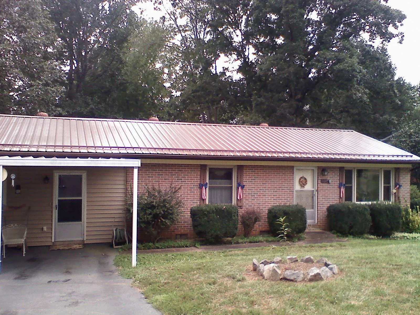 Bronze metal roof and carport on a brick ranch home — Roof Repair work by our crew in Byron